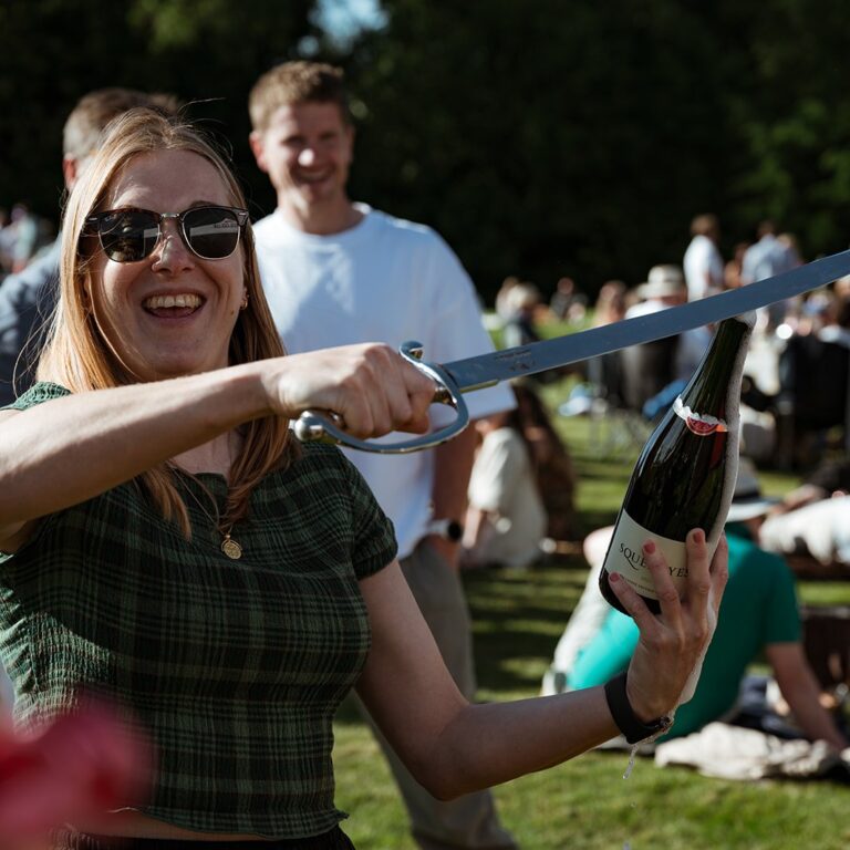 Woman in a green checked top performing sabrage